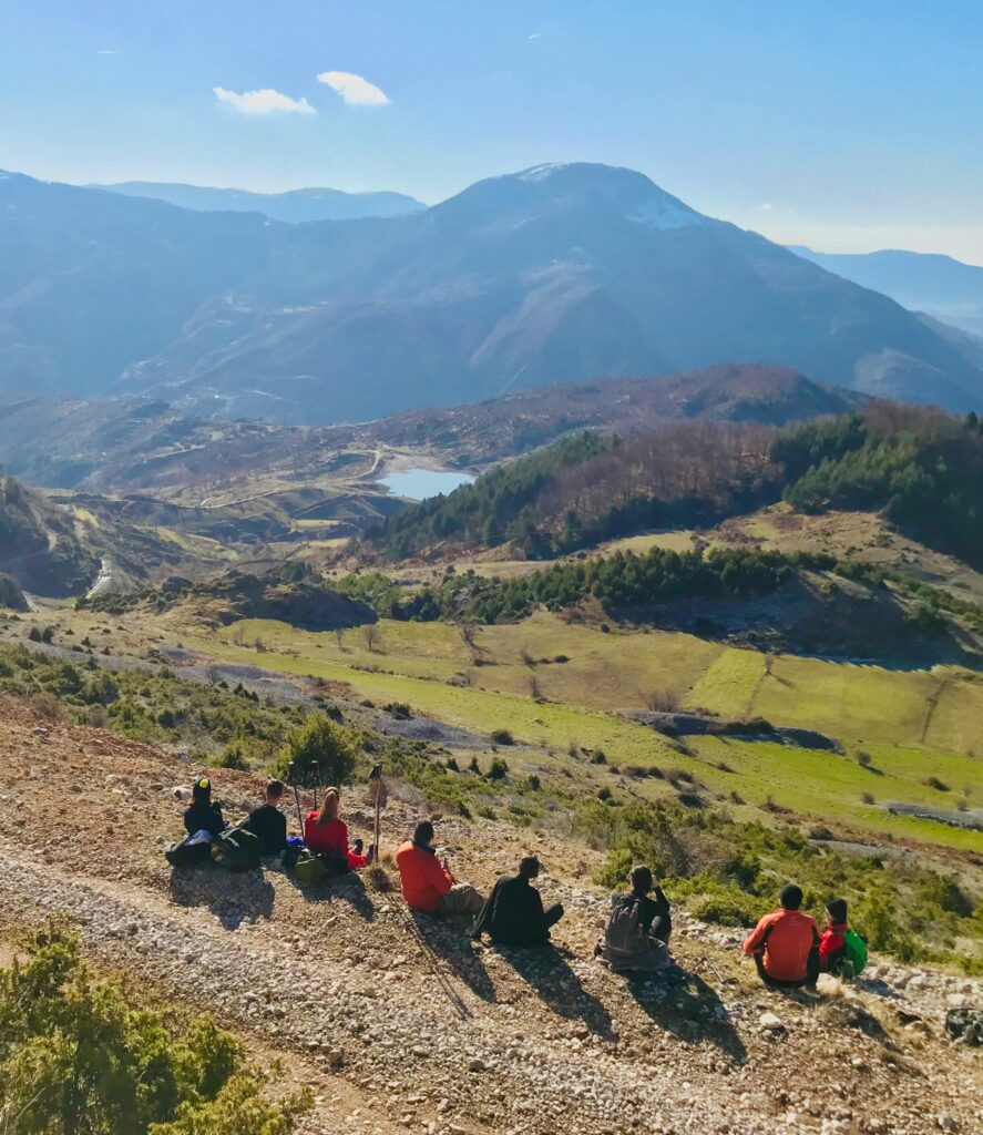 Group of hikers resting with a breathtaking view of the mountains in Shëngjergj, Tirana County.