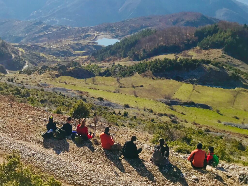 Group of hikers resting with a breathtaking view of the mountains in Shëngjergj, Tirana County.