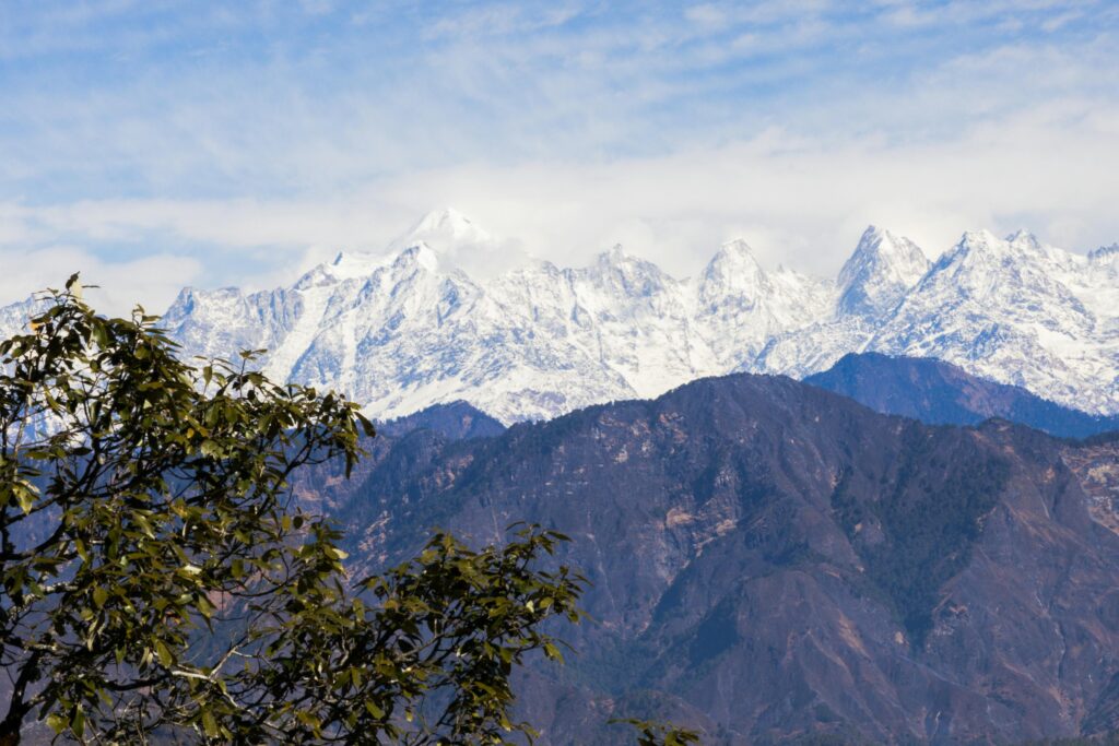 Breathtaking view of the snow-capped Himalayan mountains in Uttarakhand, India with lush foreground.
